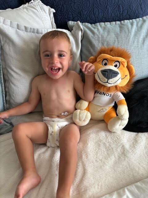 Carson with a fuzzy friend created to help educate kids about feeding tubes.